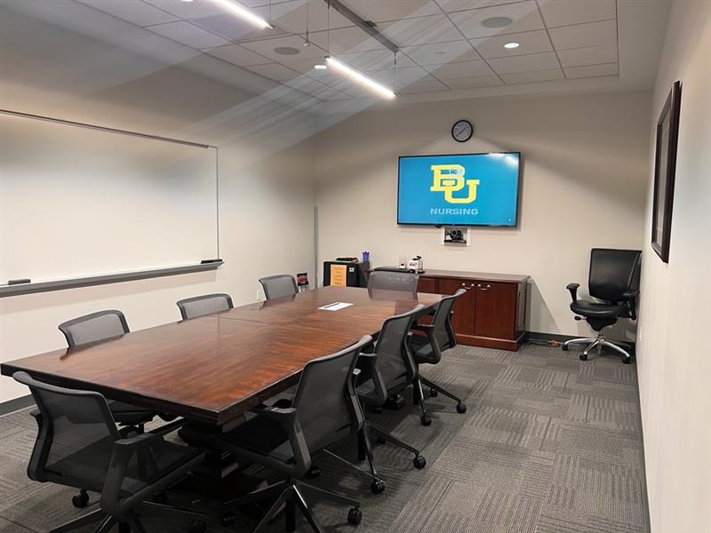 Conference room with a table, chairs and mounted TV