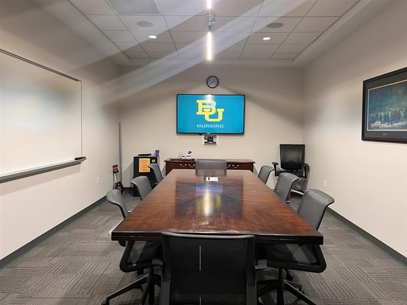 Conference room with a table, chairs and mounted TV