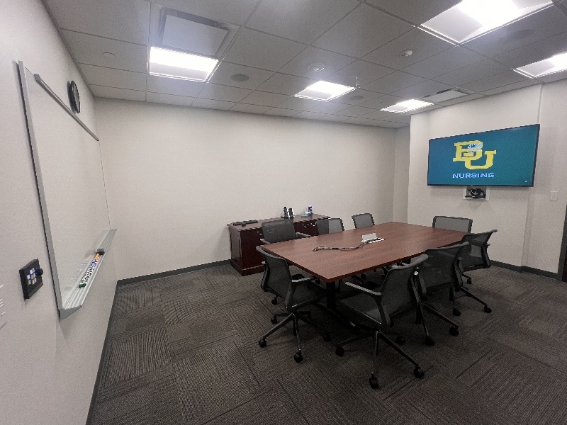 Conference room with a table, chairs and mounted TV
