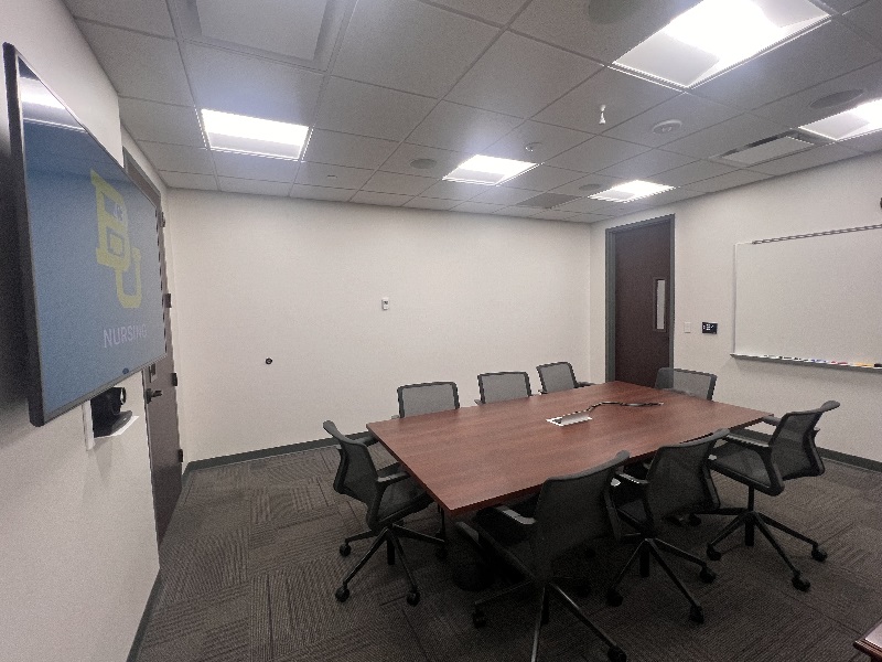 Conference room with a table, chairs and mounted TV